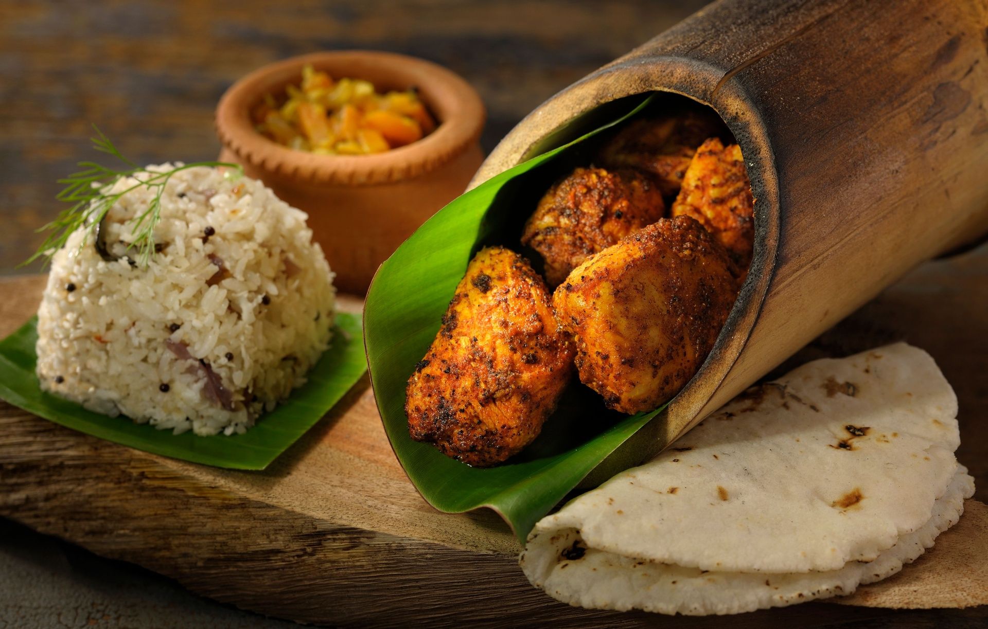 Bamboo chicken with rice and flatbread on a board.