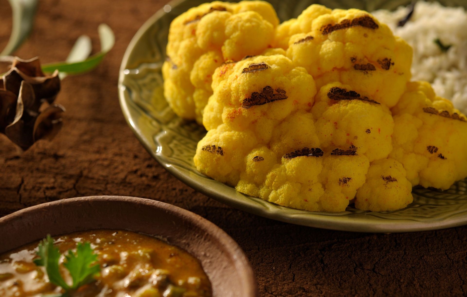 Roasted cauliflower florets with char marks and curry.