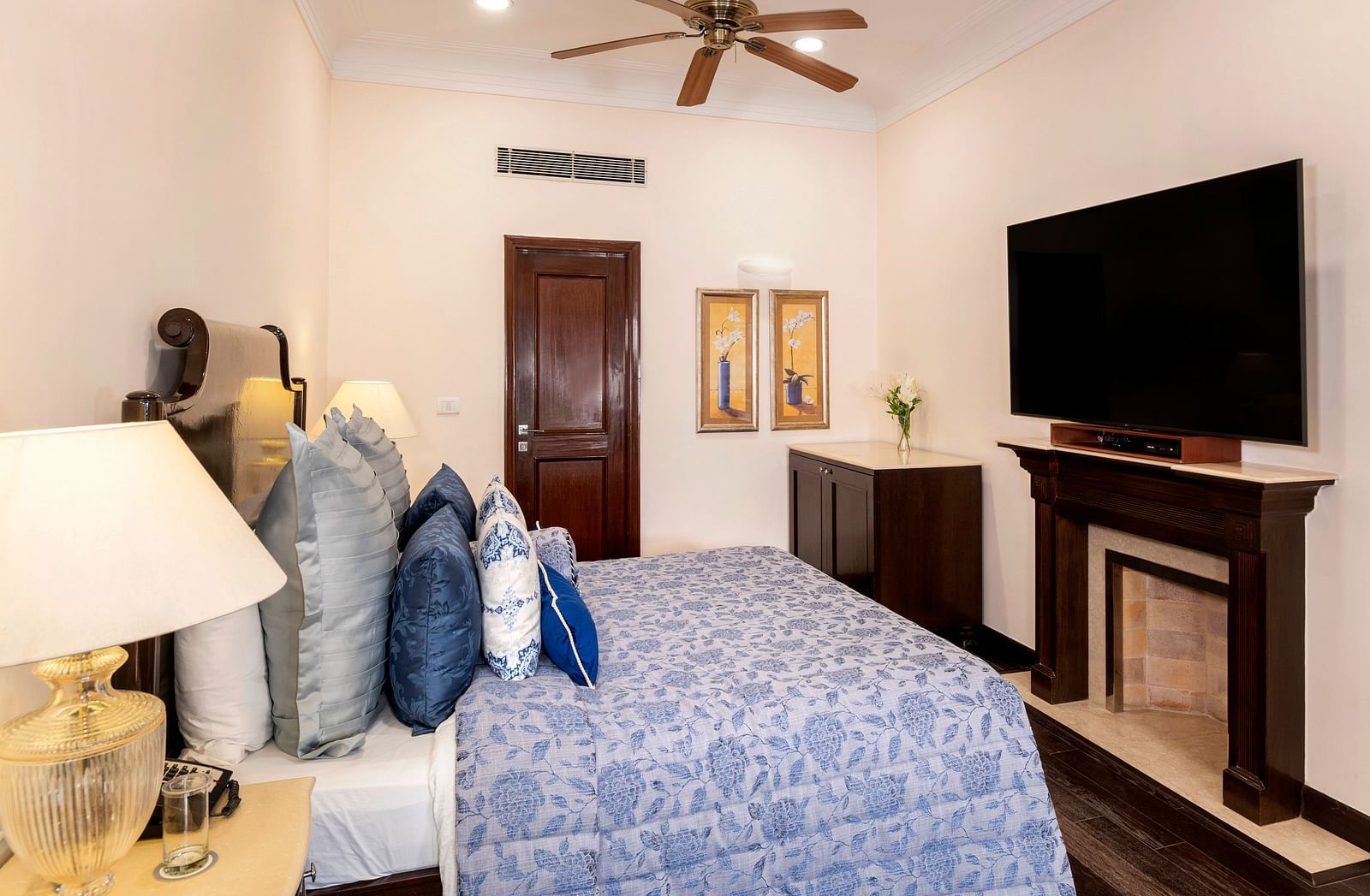 image of the Claridges Room awith a king size bed and a wall mounted TV above the fireplace at The Claridges Nabha Residence