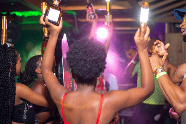 People dancing and celebrating at a lively nightclub with vibrant lights and an energetic party atmosphere, showcasing the nightlife vibe near Hotel 39 in Montego Bay.
