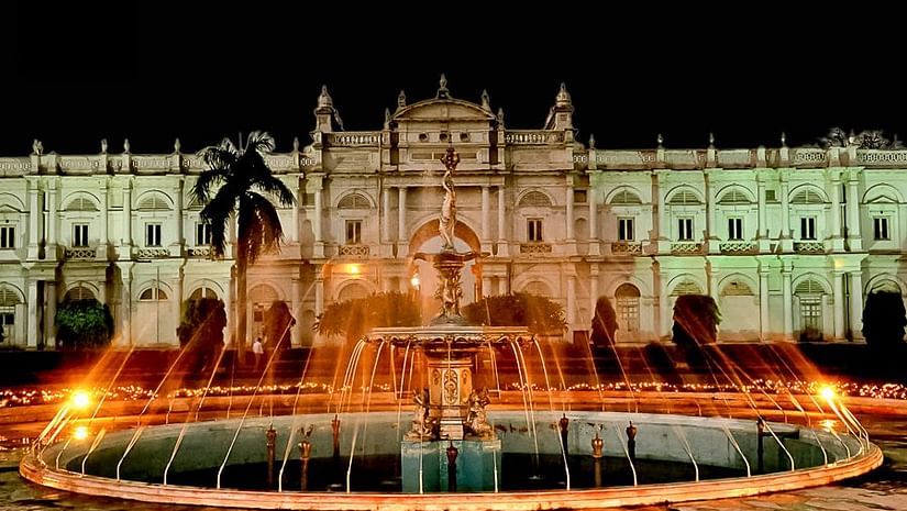 a brown coloured palace with a water fountain in front of it