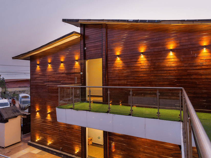 Exterior of Amara Oceanfront Resort, Baga, with an outdoor swimming pool, and chic lighting on the sides of the building.