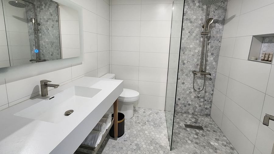 A modern bathroom with sleek white fittings and a glass shower partition - Hotel 39, Jamaica