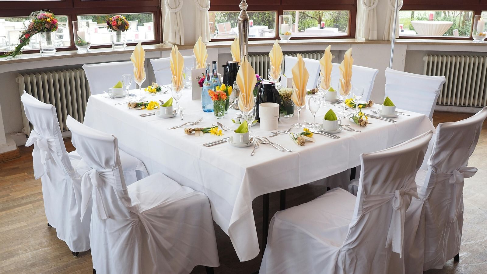 A table and chairs, elegantly decorated and arranged for an event.