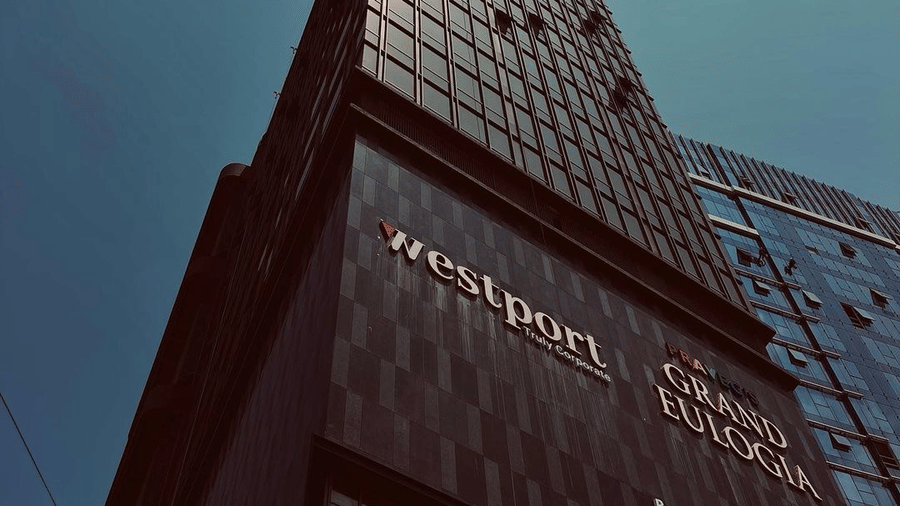 A low-angle perspective of the hotel's sleek architectural design against a bright sky - Praveg's Grand Eulogia, Ahmedabad