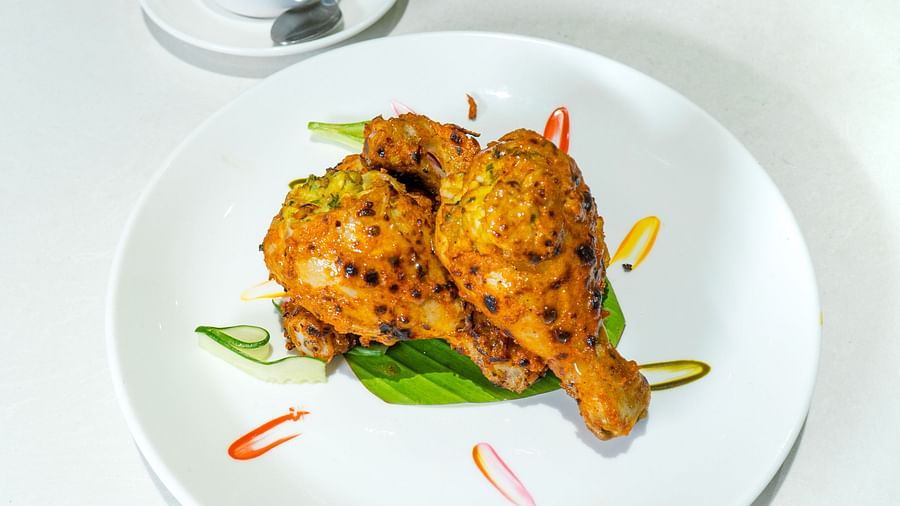 Plated roasted chicken served with decorative garnishes and sauce.