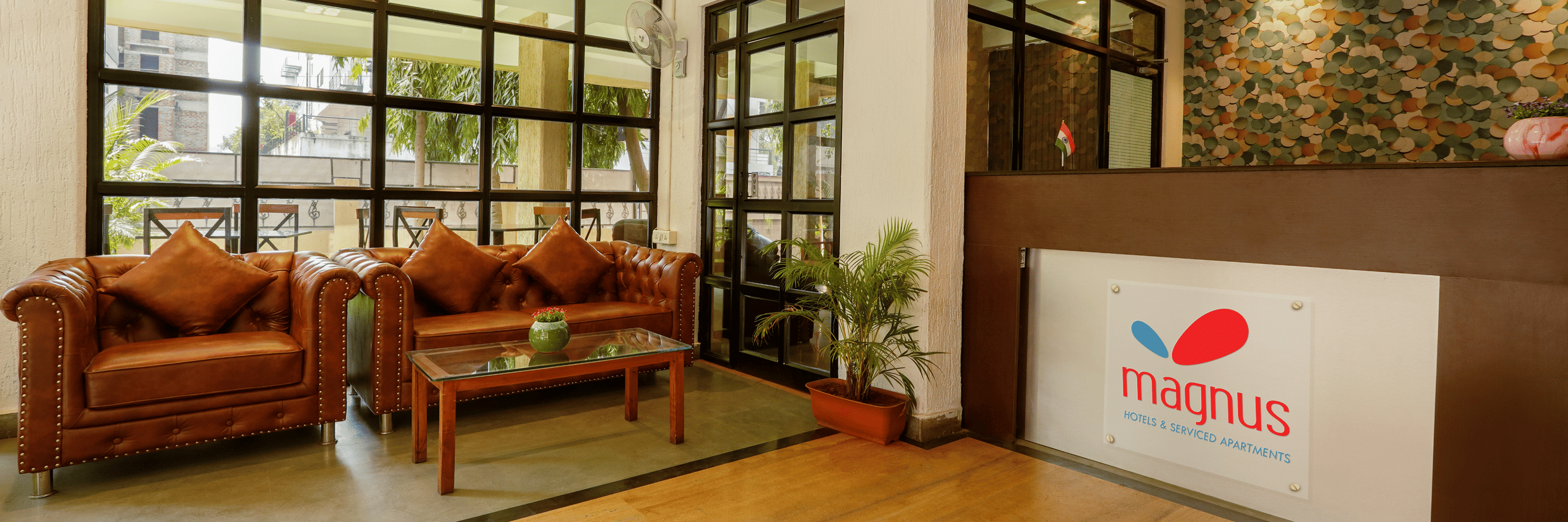 Image of a lobby featuring the seating area and large windows - Magnus Calypso Suites, Viman Nagar