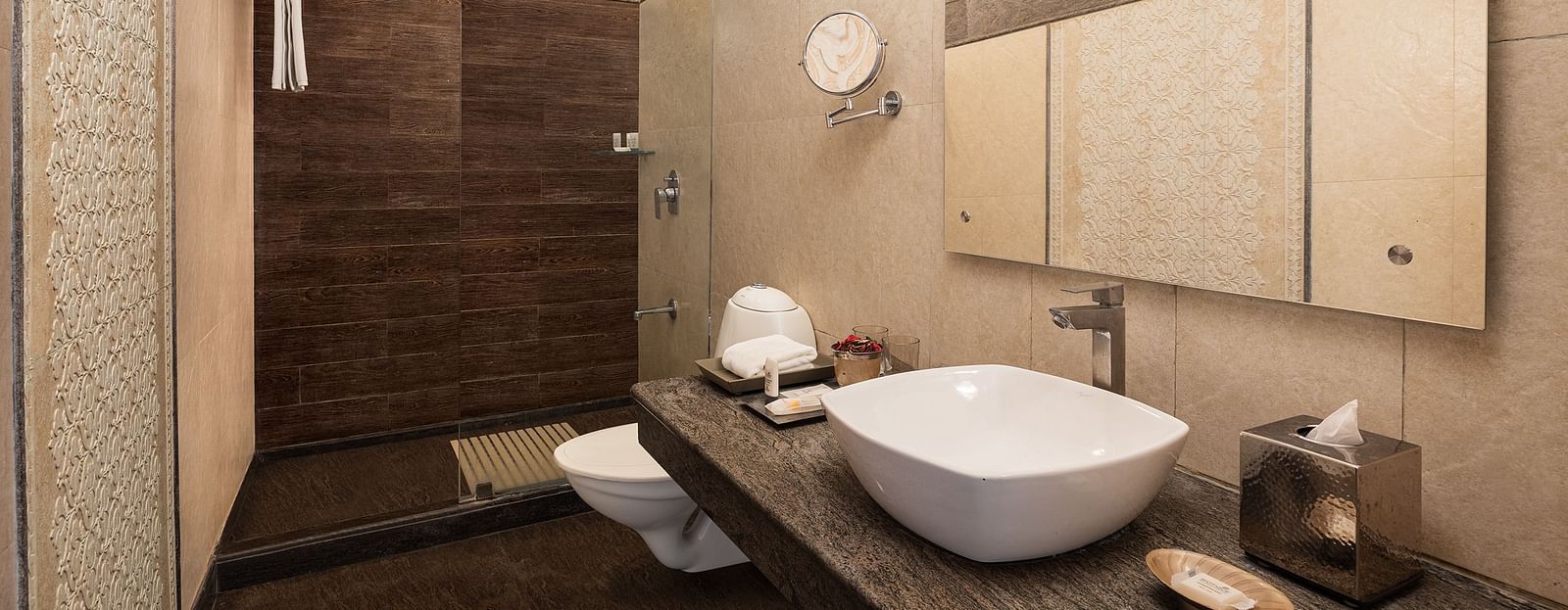 An image featuring a washroom, a big mirror,  the glass separator for bath area - The Naini Retreat, Nainital.