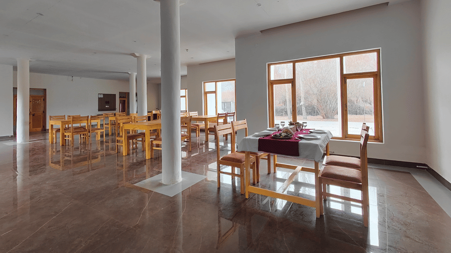 A wide-angle shot of the clean, modern restaurant space showing multiple dining setups at Indus Serenity Retreat.
