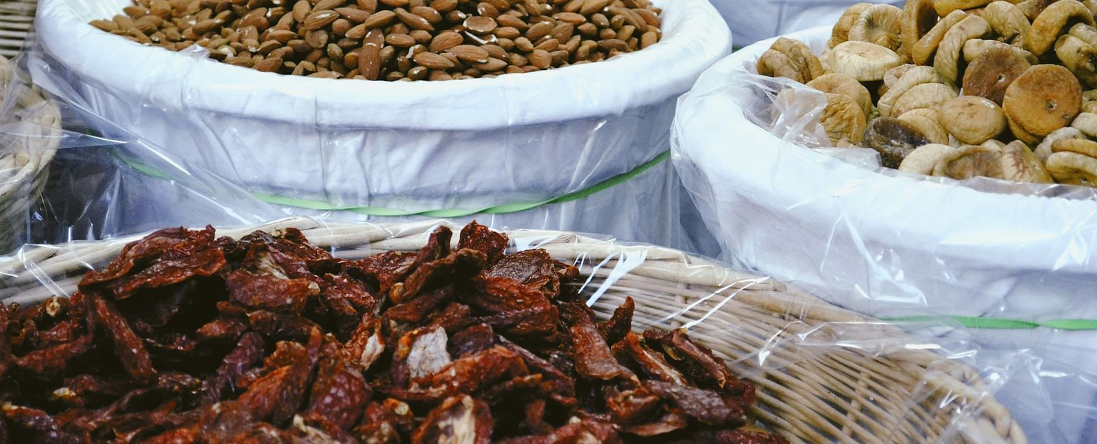 A close up shot of many types of dry fruits kept in individual bags to be sold.
