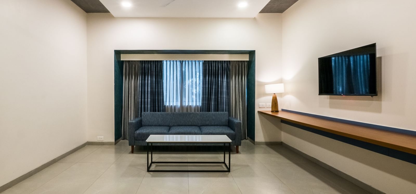 A spacious hotel living area with a television and comfortable seating, ideal for relaxation at Shilton Dee Cee.