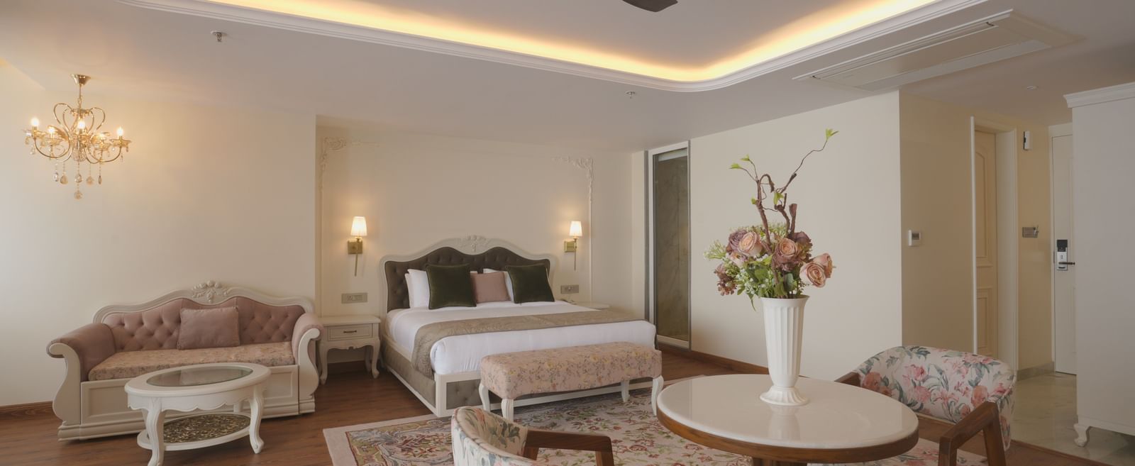 Lounge area with floral chairs, wooden flooring, and warm ceiling lights - Mayfair Cafe & Suites, Dalhousie