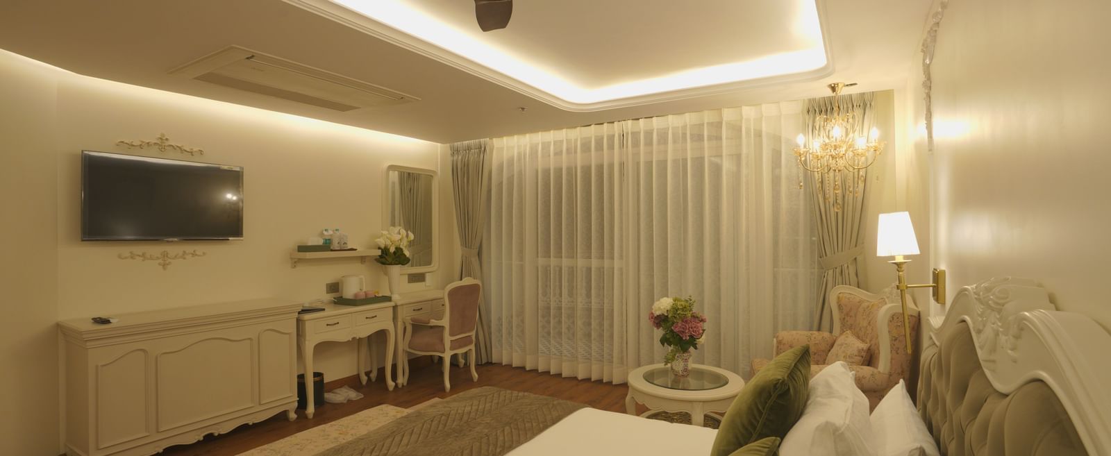 Elegant bedroom with a ceiling fan, muted lighting, and tasteful furnishings - Mayfair Cafe & Suites, Dalhousie