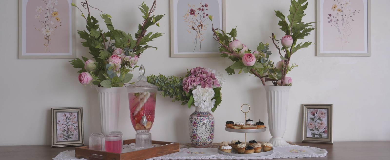White sideboard decorated with vases of fresh flowers and framed artwork - Mayfair Cafe & Suites, Dalhousie