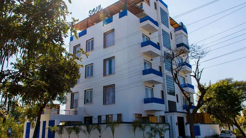 Facade view of The Sierra, Udaipur with trees next to the building and blue sky in the background