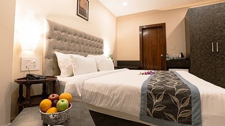 Elegant room with a bed, fruit bowl on the bedside table, and tufted headboard at The Verda de Miranda Resort.
