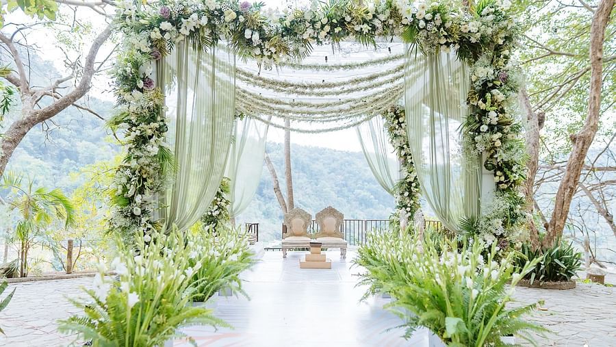 Wedding setup with floral decorations and greenery in an outdoor venue
