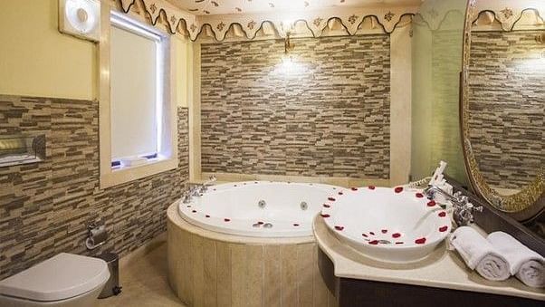 Image of washroom with a jacuzzi decorated with rose petals Rajasthali Resort & Spa Jaipur.