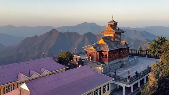 A tranquil shot of a traditional hilltop temple at dusk, showcasing beautiful architecture with a stunning mountainous horizon.