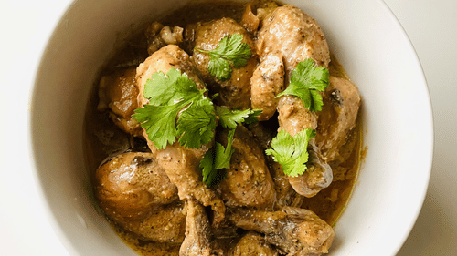 image of Chicken curry served in a bowl topped with coriander leaves
