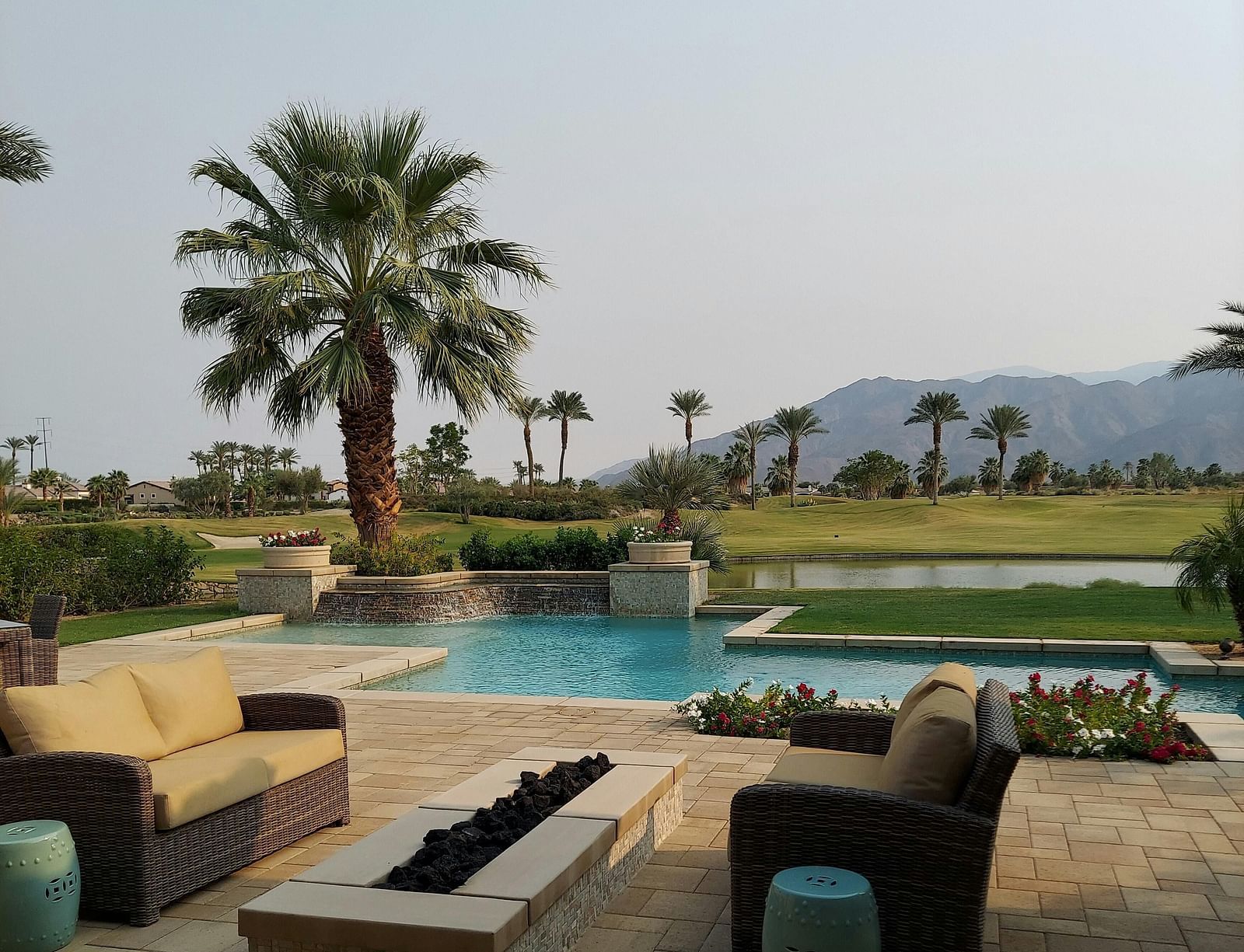 A beautiful landscape with a swimming pool along with a mountain range in the background.