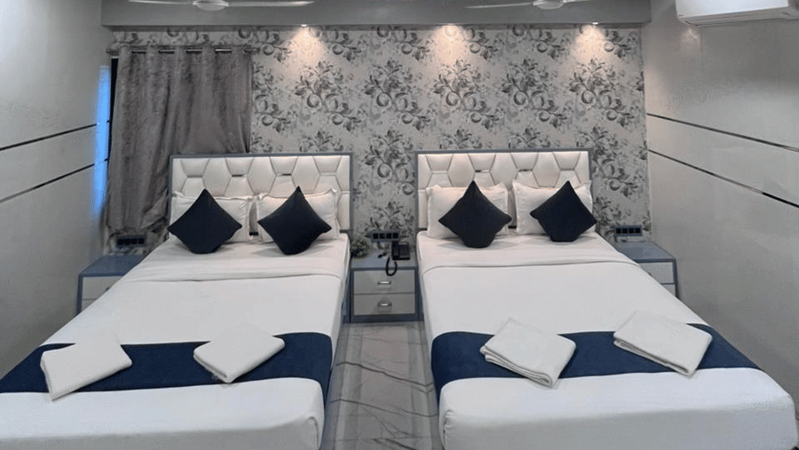 Stylish twin-bed hotel room with modern décor, comfortable bedding, and warm lighting.