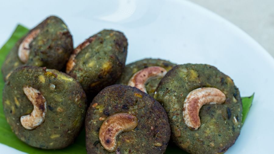 Plated traditional snack garnished with cashew nuts, served on a leaf.