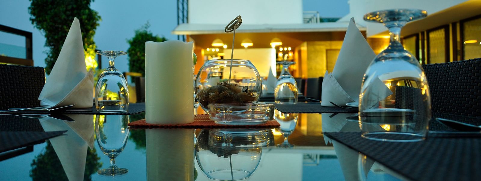 candles, napkins and glass kept on a table at Hotel Atithi - TGI Grand, Pondicherry