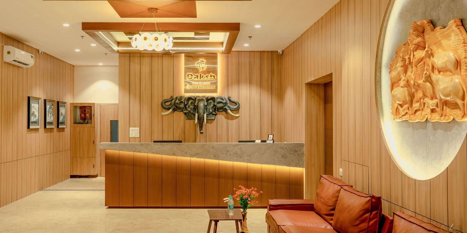 Reception area of Daksh The Grand Gowardhan, Dwarka, with a sleek desk, seating, and ambient lighting.