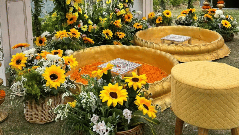 Wedding decor featuring a round mirror framed with sunflowers and yellow seating at The Manor Sports & Wellness Hotel.