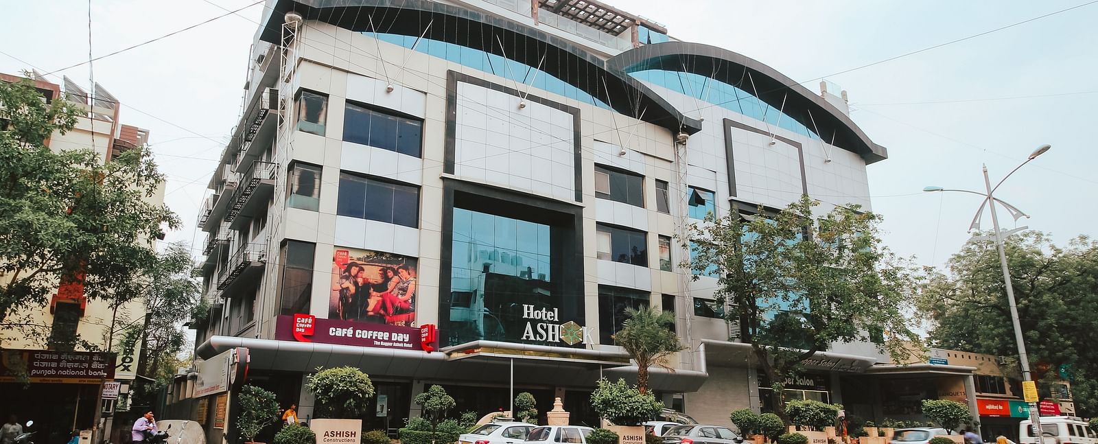 The front view of Hotel Ashok Nagpur, featuring its facade, entrance, and the street in front. 