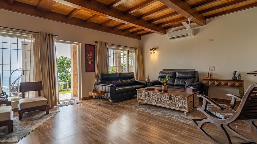 an overview of a living room with sofas and a coffee table inside one of the rooms - neer ganga Resorts