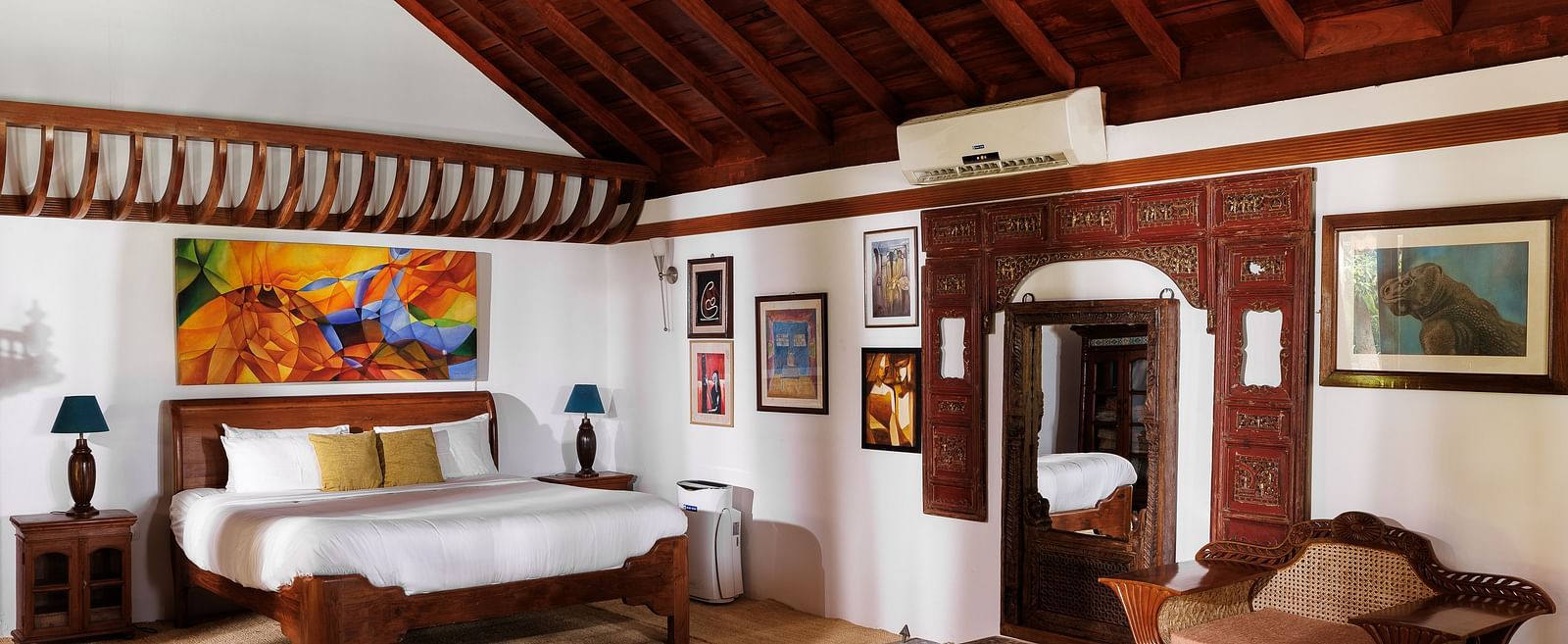 A wooden interior room with wooden furnitures such as a bed, a sofa set, a coffee table, and paintings - BluSalzz Villas - Muhamma Resort, Alleppey