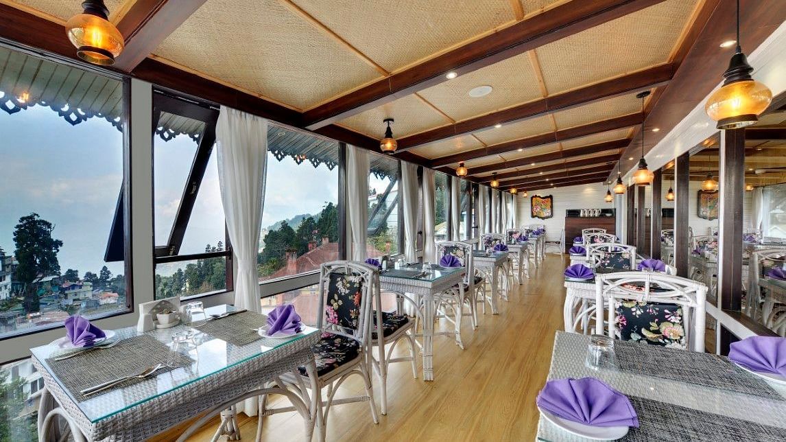 image of a dining space with a slanted roof and lights hanging from the ceiling at Yashshree Mall Road, Darjeeling.