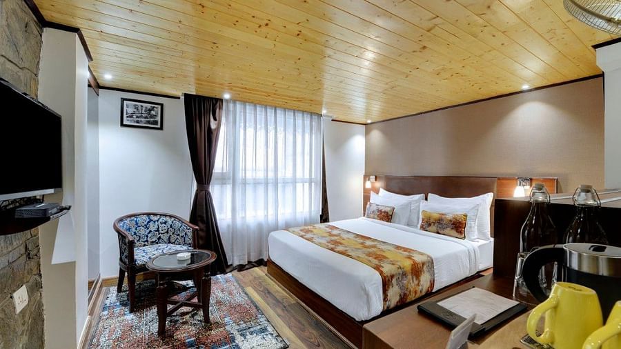 Image of a room with sitting area, a bed and a television in front at Yashshree Mall Road, Darjeeling.