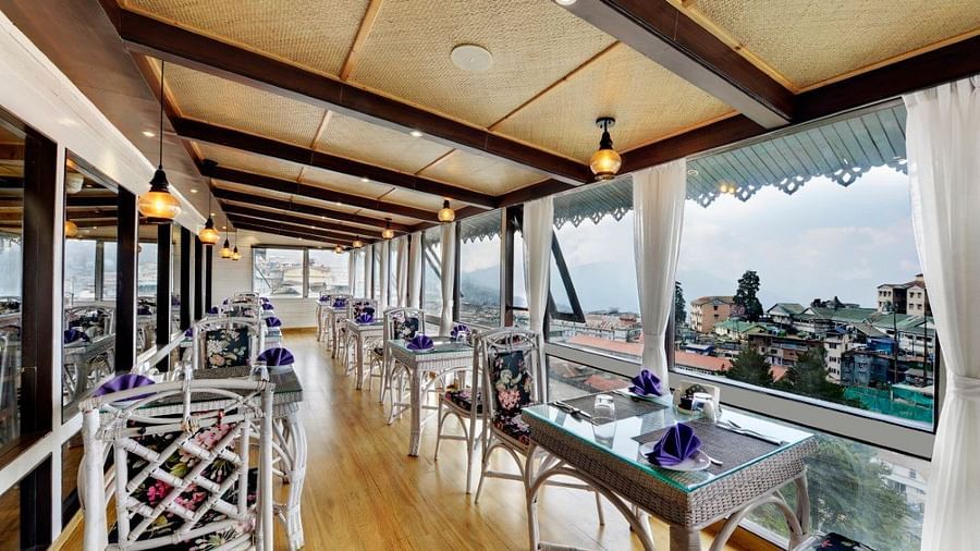 Image of a dining space with seating area and view of the surrounding are at Yashshree Mall Road, Darjeeling.
