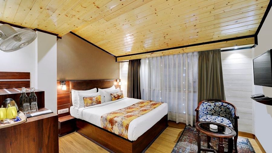 Image of a room with a bed, a seating area and a television at  Yashshree Mall Road, Darjeeling.