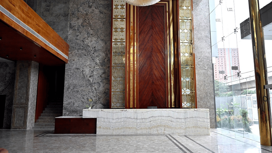 An empty reception desk with ample of natural light coming from outside through the glass door at Leroy Grand, Yeshwanthpur.