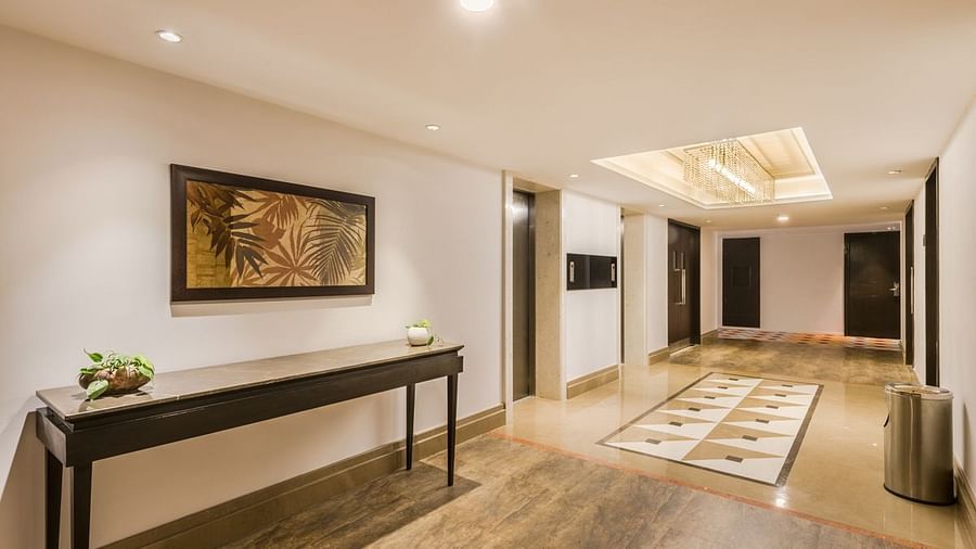 A Hotel corridor with wall art, long console table, and stylish lighting - TGI Grand Fortuna, Hosur