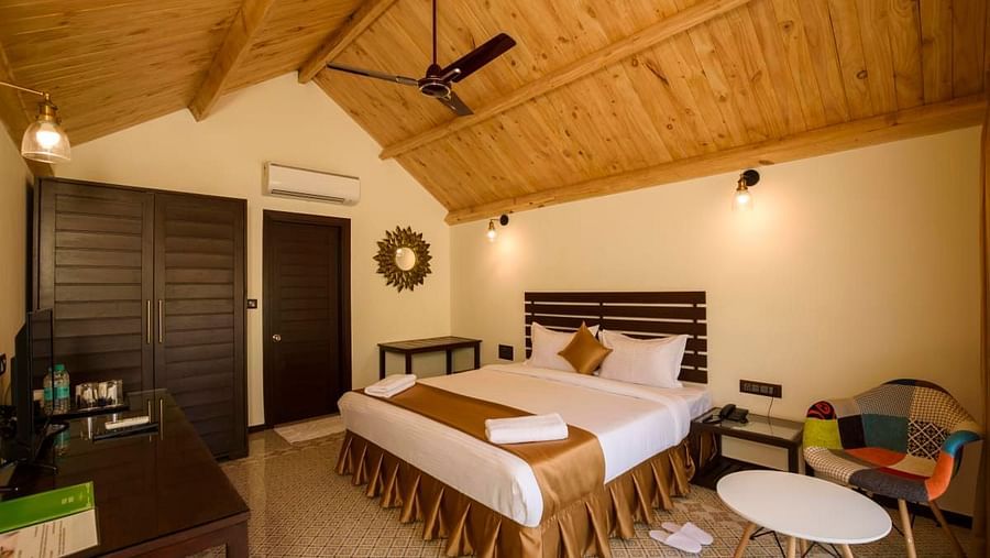 A cozy and comfortable bed beneath a wooden ceiling at Stone Wood Resort, Mandrem