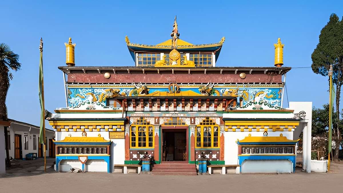 Colourful Buddhist monastery with ornate golden details, standing against a clear blue sky.
