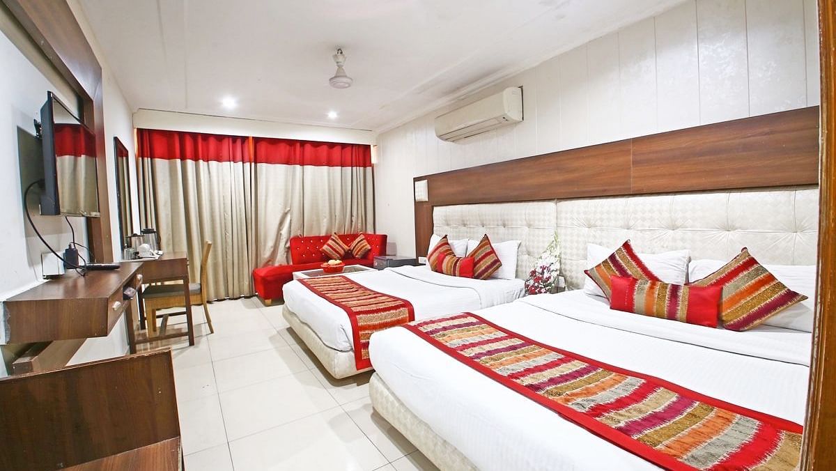 Family Room featuring a work desk, large window with curtains, and two queen size beds -  Hotel Diamond Plaza, Chandigarh.