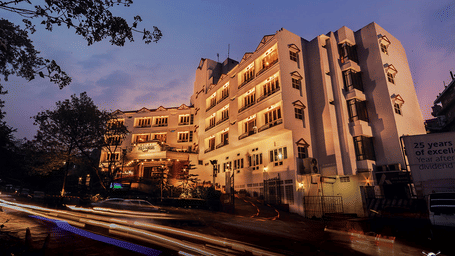 A hotel building lit up in the evening with car trails in front - Polo Hotel Shillong