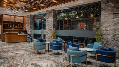 A modern hotel lobby with a coffee table and blue chairs.
