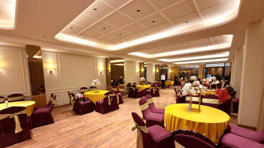 A banquet hall with round tables, neutral decor and soft lighting at Arnisa A Boutique Hotel
