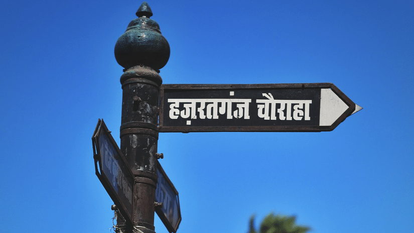 Street signpost in Hindi with colonial-style buildings in the background.