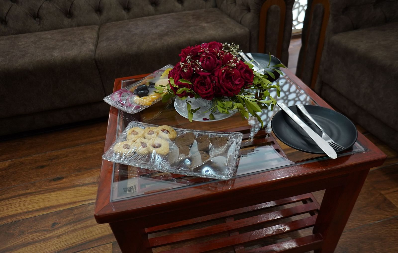 A close-up shot of a small wooden table with snack platter and floral arrangement - Bamboo Saa Mulberry Resort, Pushkar
