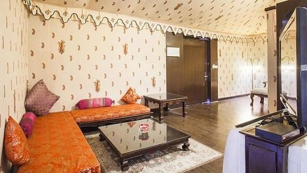 Image of a room with seating area and a table in front at Rajasthali Resort & Spa Jaipur.