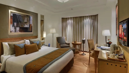 A room with polished wooden floors and a large bed at Eastlynn Collections Huda City Centre, Gurugram.