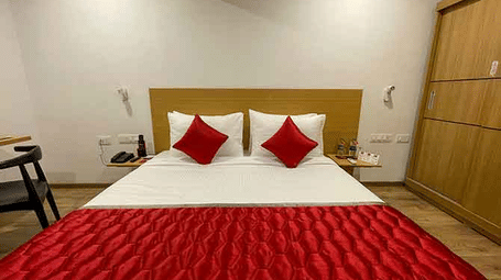 A hotel room with a red-and-white coloured bed.
